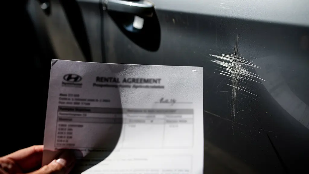 Main tenant un document d'état des lieux devant une voiture avec transition vers le dommage réel