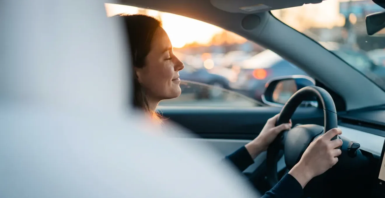Conducteur serein au volant d'un véhicule électrique dans un environnement urbain, vue de profil montrant l'isolation acoustique