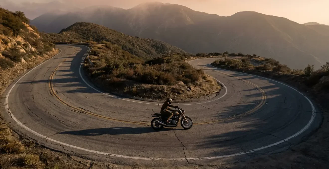 Motard négociant une épingle à cheveux en montagne avec inclinaison marquée et technique de contre-braquage